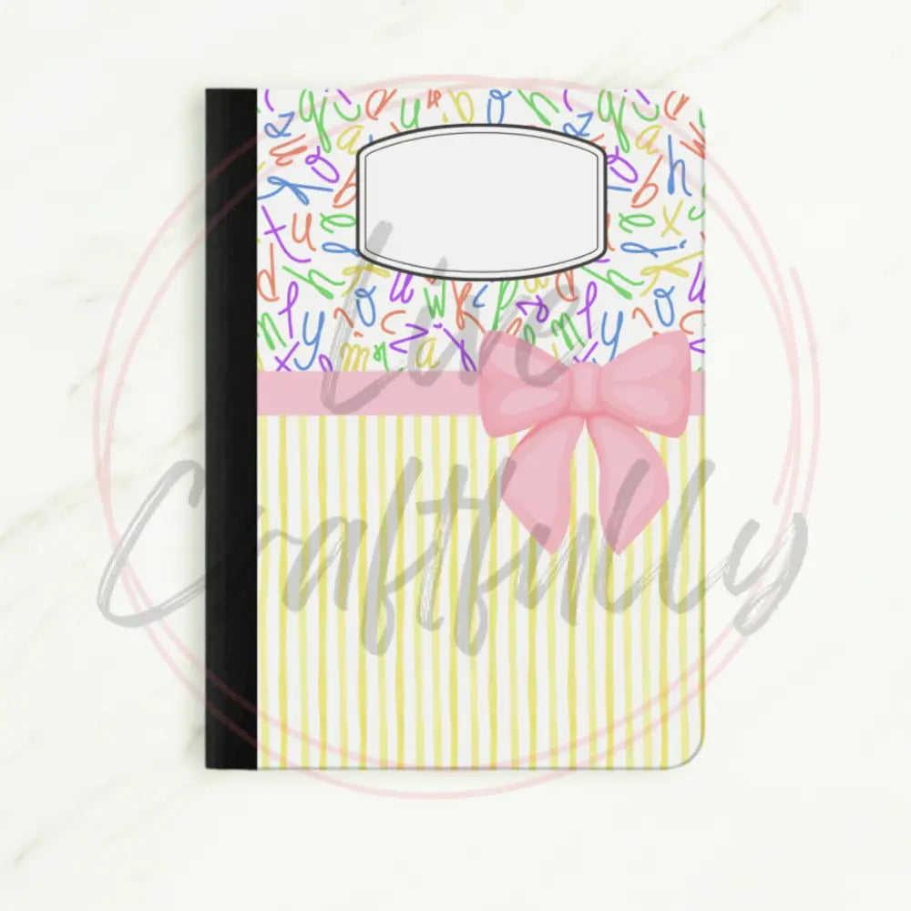 Notebook with colorful letter pattern and pink bow on a white background