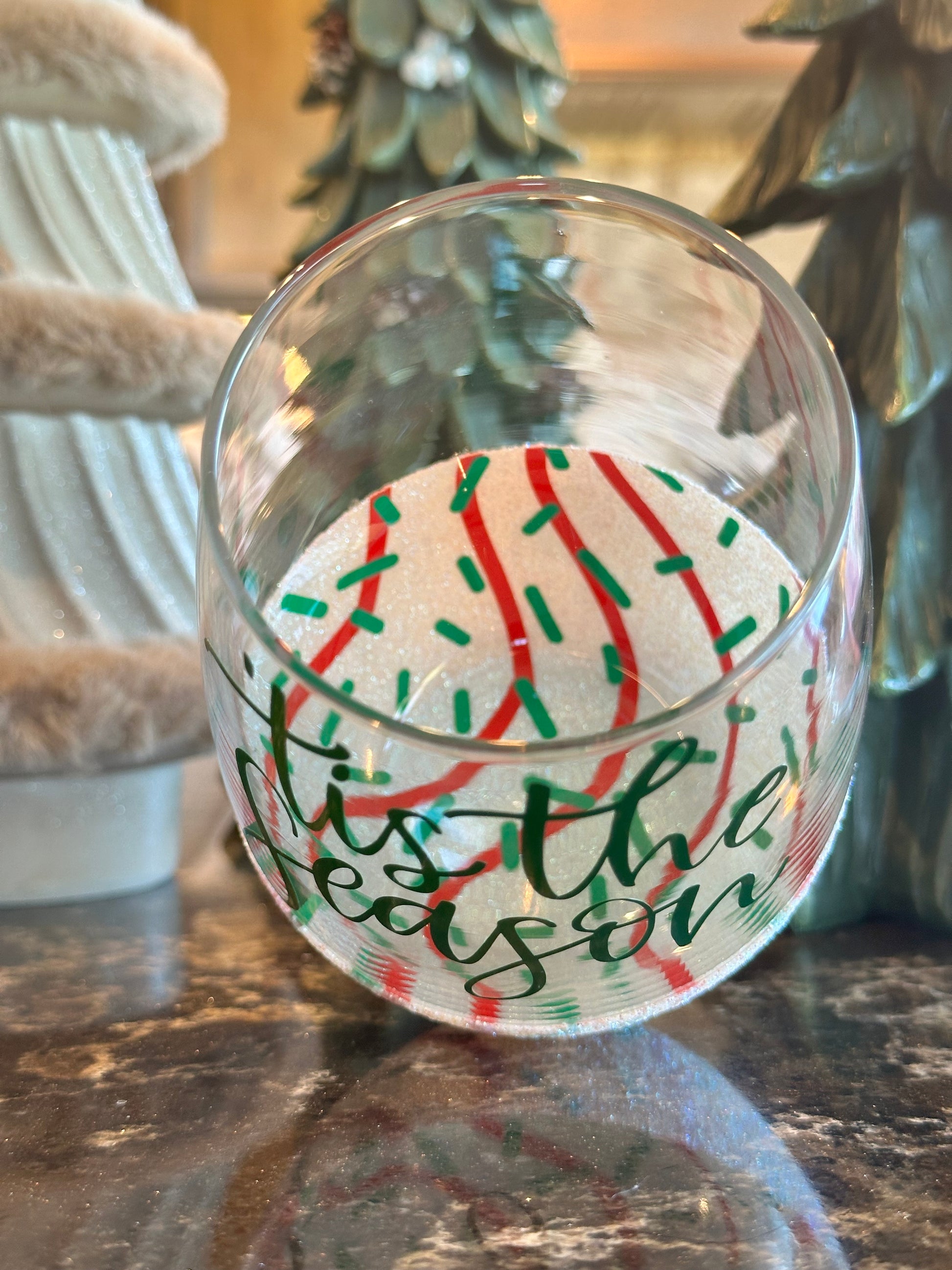 Decorative glass with festive design on a wooden surface