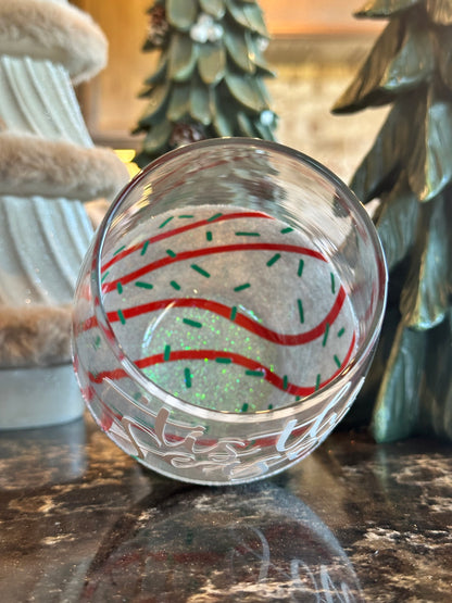 Decorative glass ball with red and green patterns on a textured surface