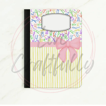 Notebook with colorful lettering and a pink bow on a white background