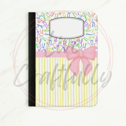 Notebook with colorful letter pattern and pink bow on a white background